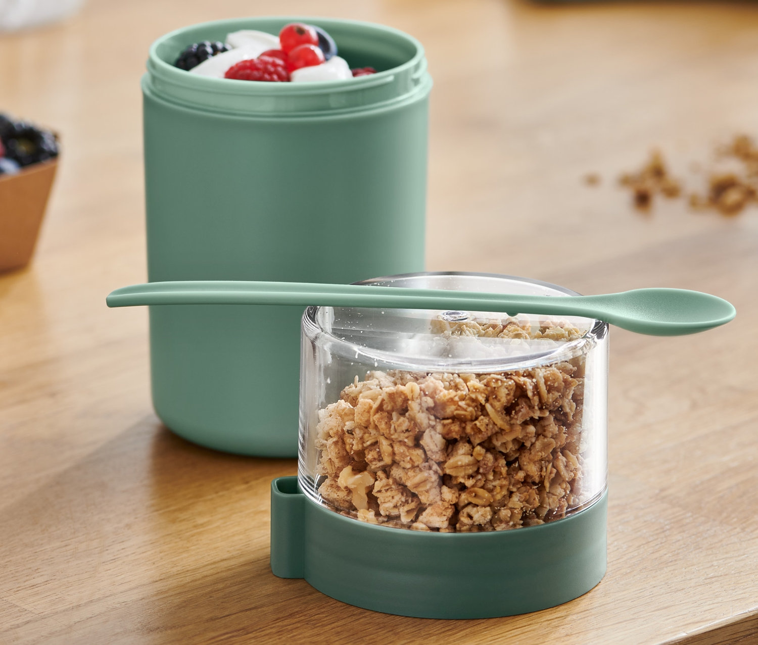 Ein To-go-Joghurt-Becher mit Müsli und Früchten ist zu sehen.