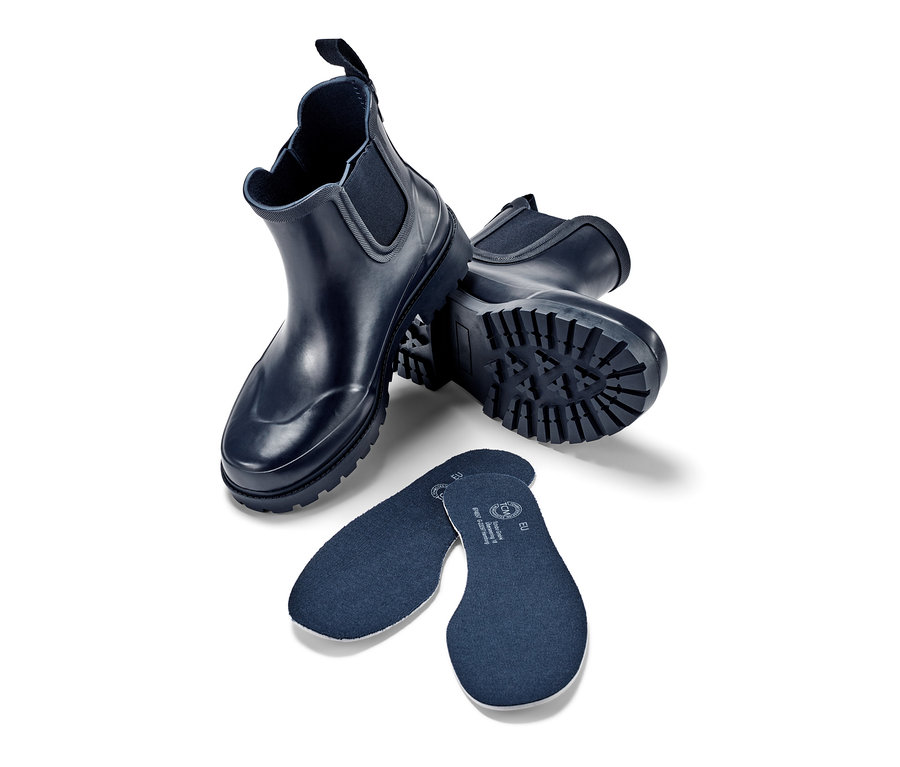 Zwei Regenstiefeletten und zwei Einlegesohlen auf weißem Hintergrund.