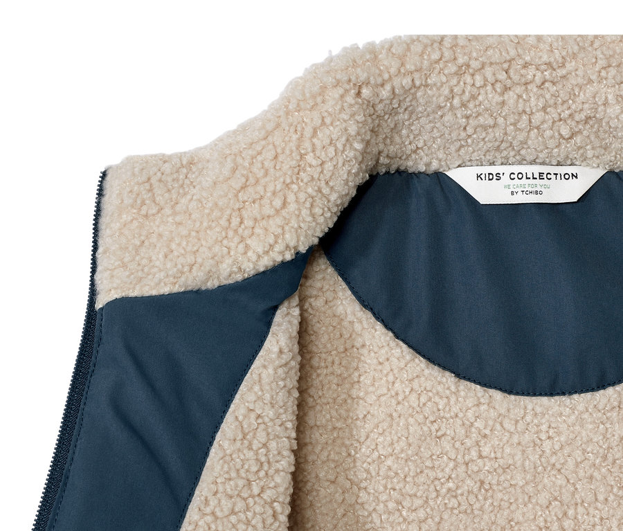 Detailansicht einer Kinder-Teddyplüsch-Steppweste, Innenseite blau.