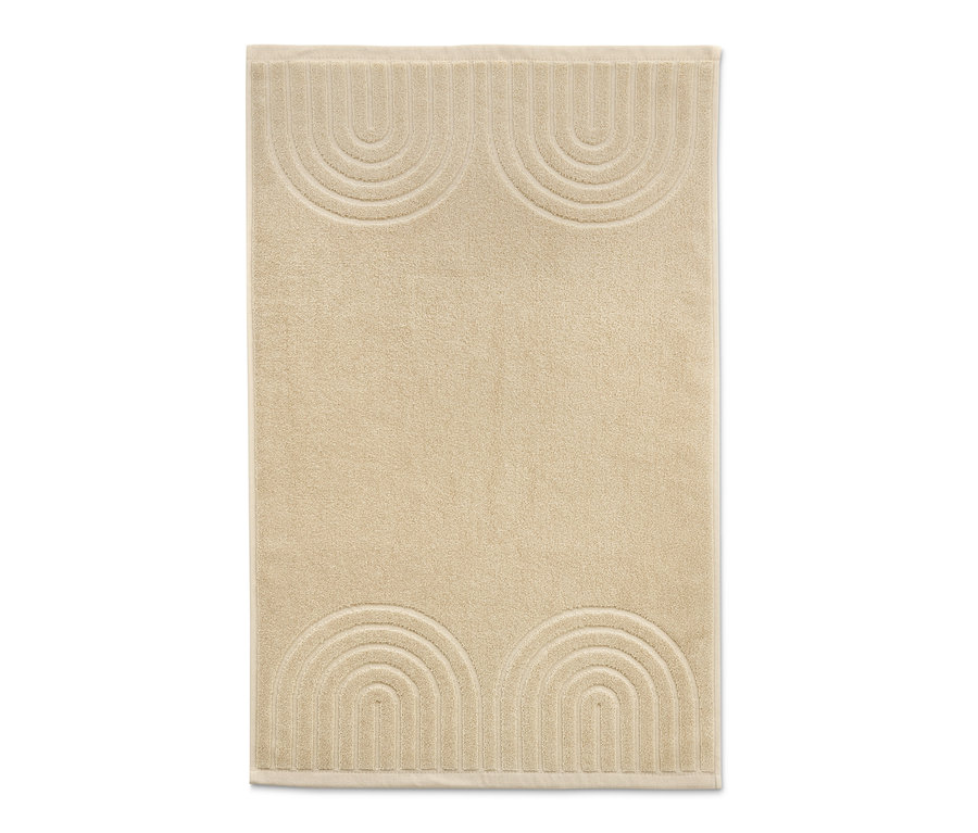 Ein cremefarbener Jacquard-Duschvorleger mit geometrischem Muster.