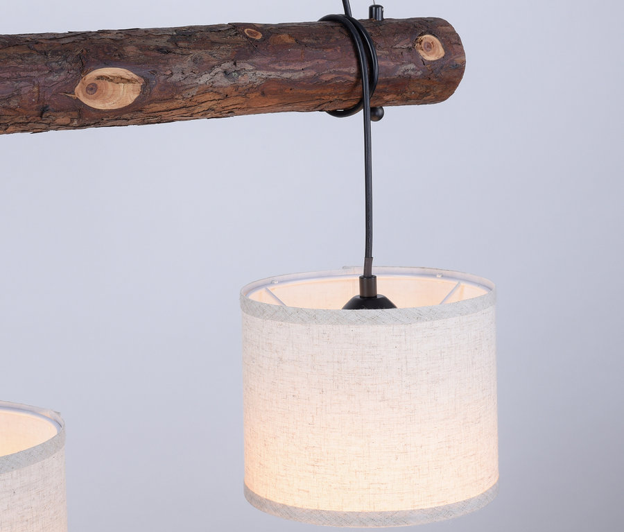Eine »Bark« Pendelleuchte aus Holz mit Stoffschirmen hängt von der Decke.