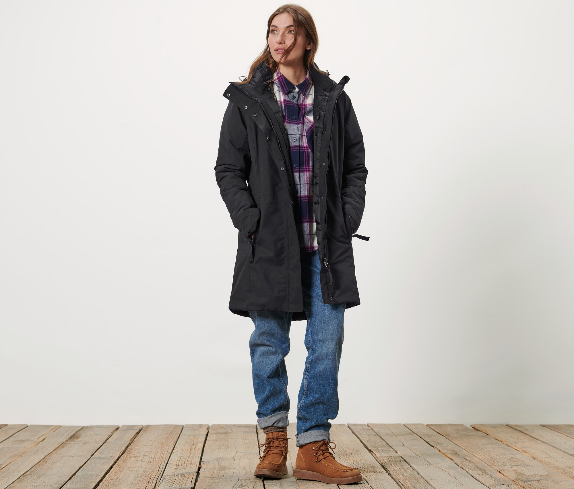 Frau steht in einem schwarzen Thermo-Mantel.