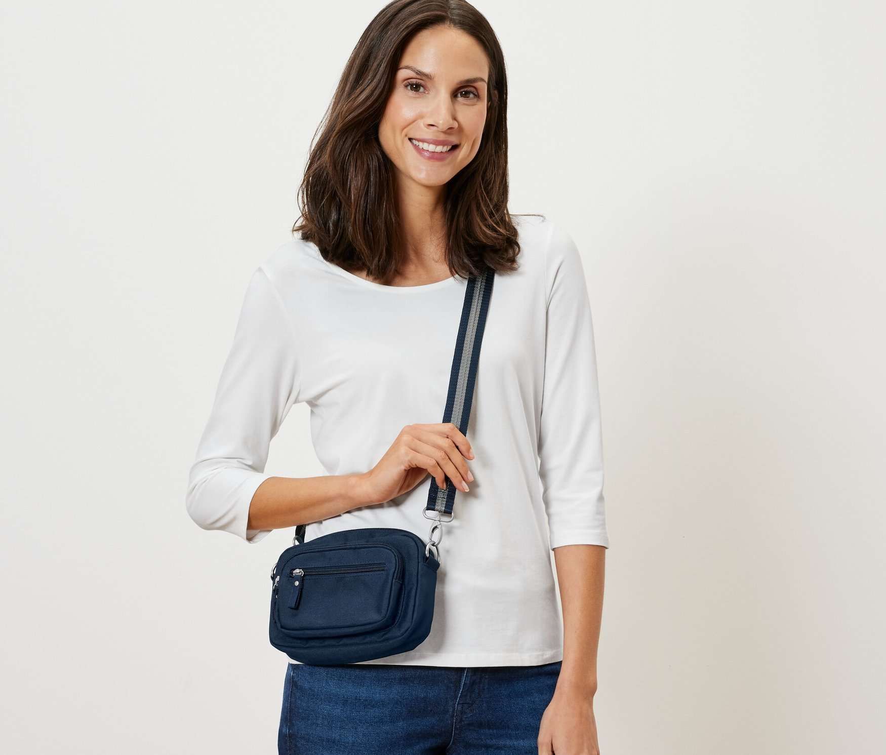 Frau posiert mit marineblauer Sicherheits-Umhänge- und Bauchtasche.