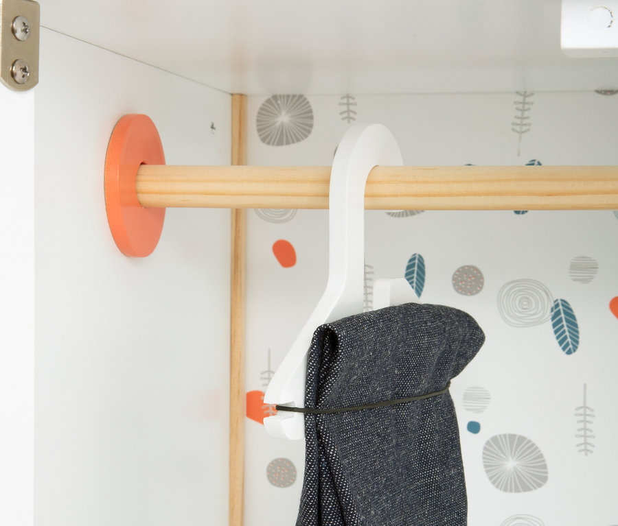 Kleidung hängt auf einem Bügel im small foot Puppenschrank »Little Button«.
