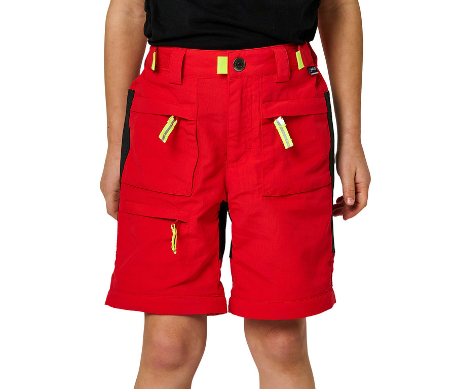 Ein Junge trägt eine rote Jako-O Zipp off Hose mit neongelben Details und schwarzen Einsätzen an den Seiten.