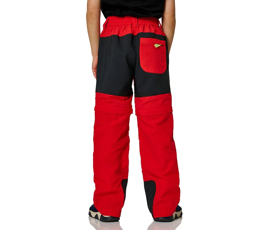 Junge steht mit dem Rücken zur Kamera und trägt eine rot-schwarze Zipp-off-Hose der Marke Jako-O.