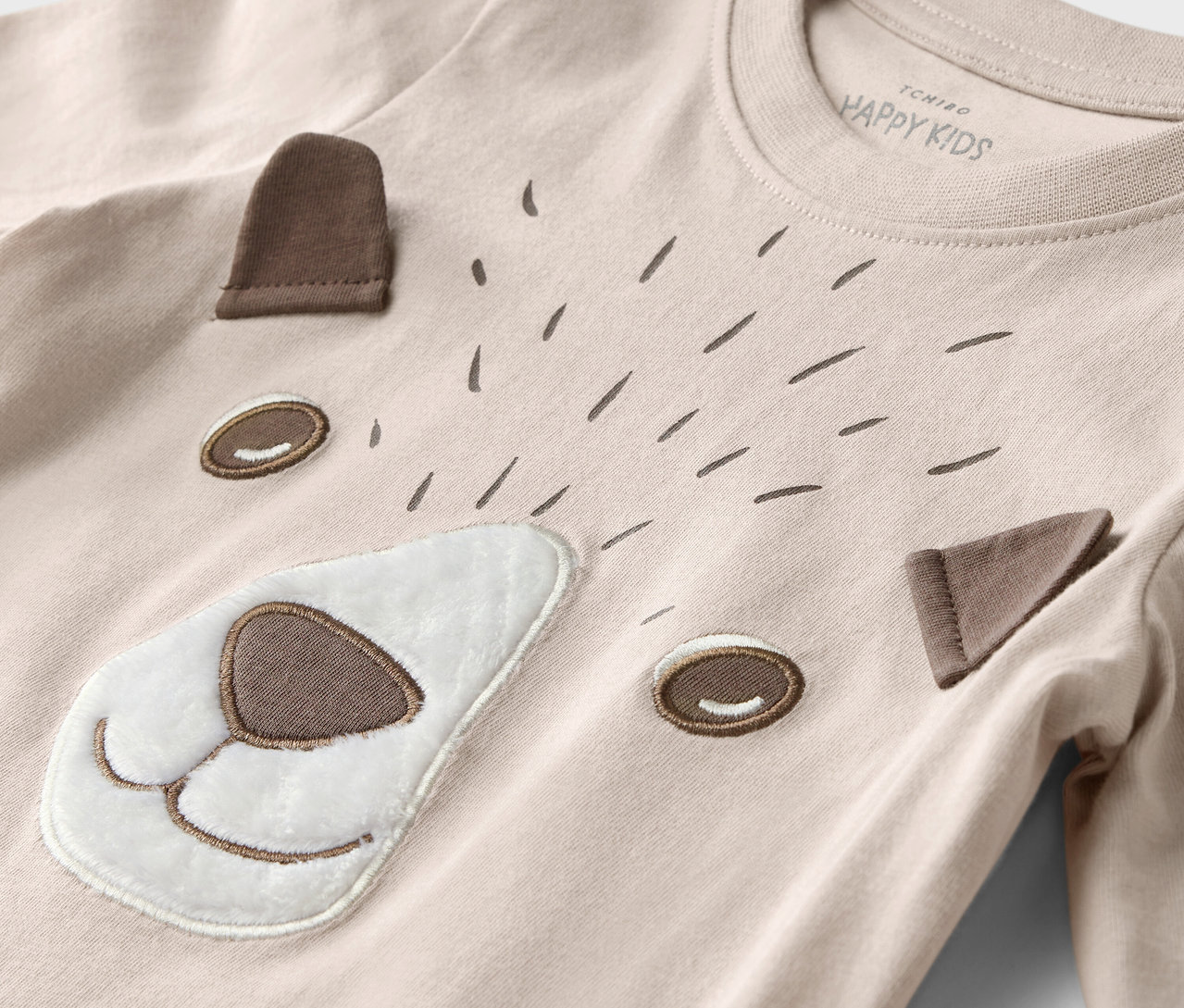 Detailansicht eines Kinder Langarmshirts mit einem Bärengesicht und Waldtiermotiv.