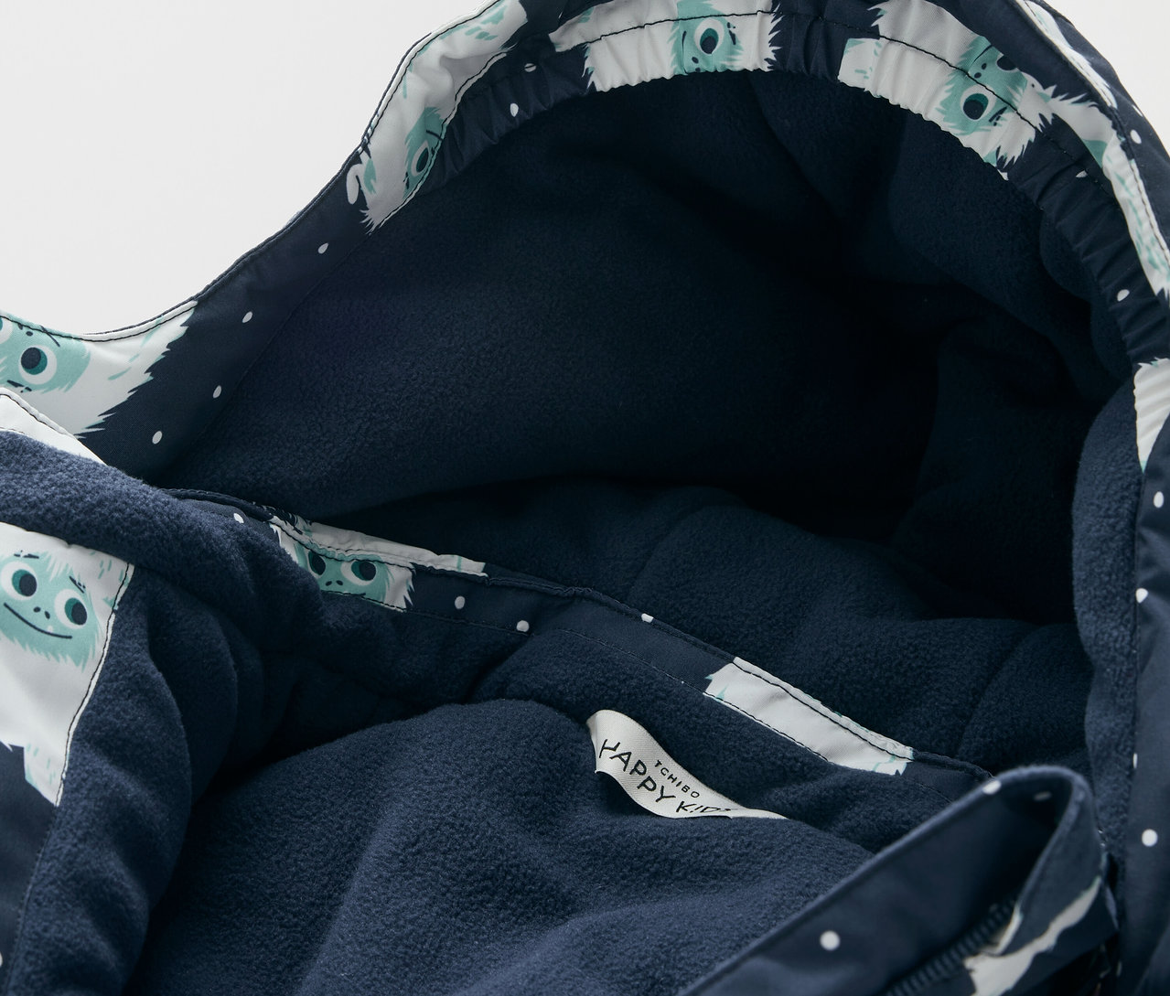 Detailansicht einer Jacke mit Kapuze, dunkelblauem Futter und einem weißen Figuren-Muster.