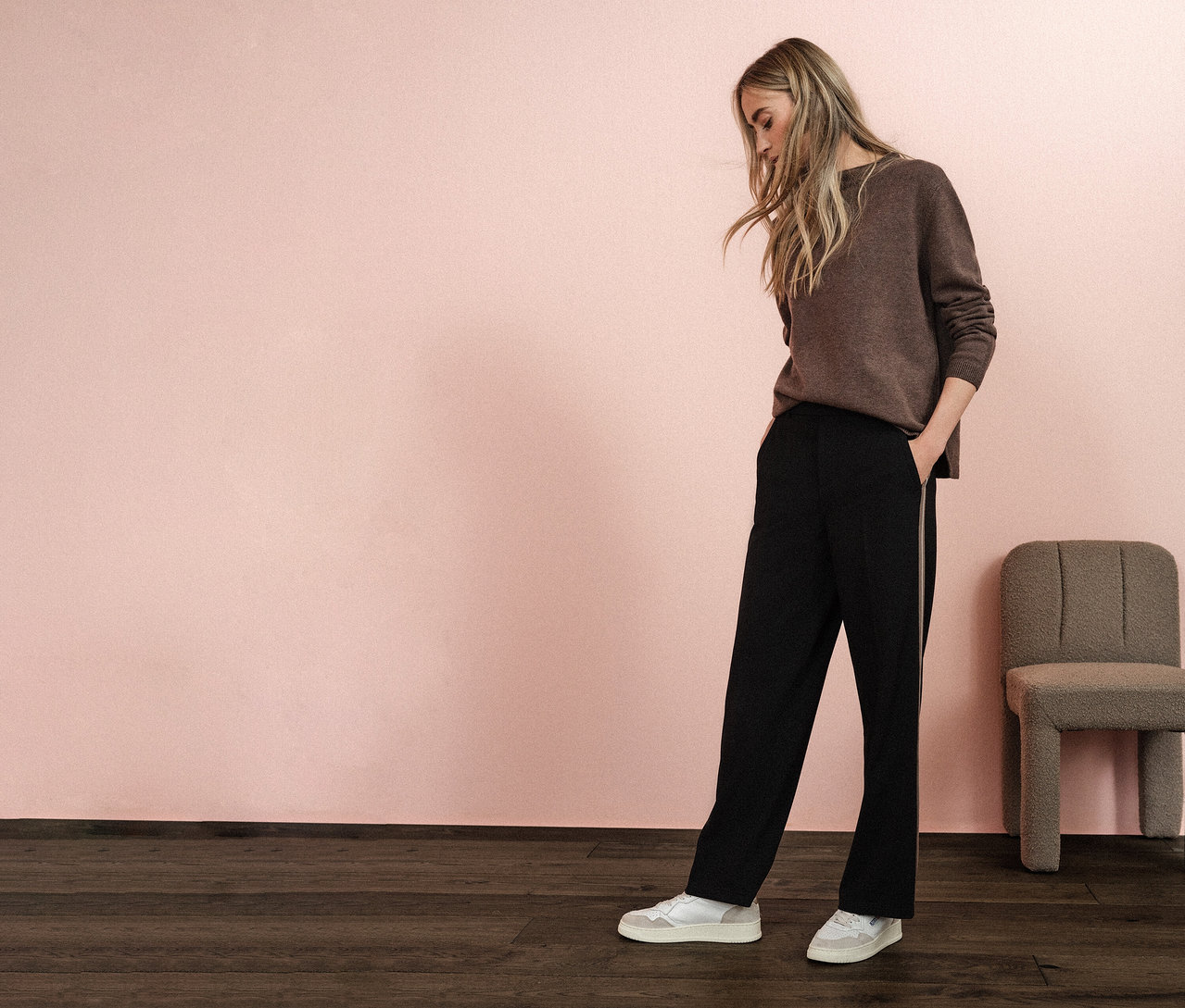Frau mit braunem Pullover und schwarzen Street One Straight Leg Hose mit Gallon, die Hände in den Hosentaschen.