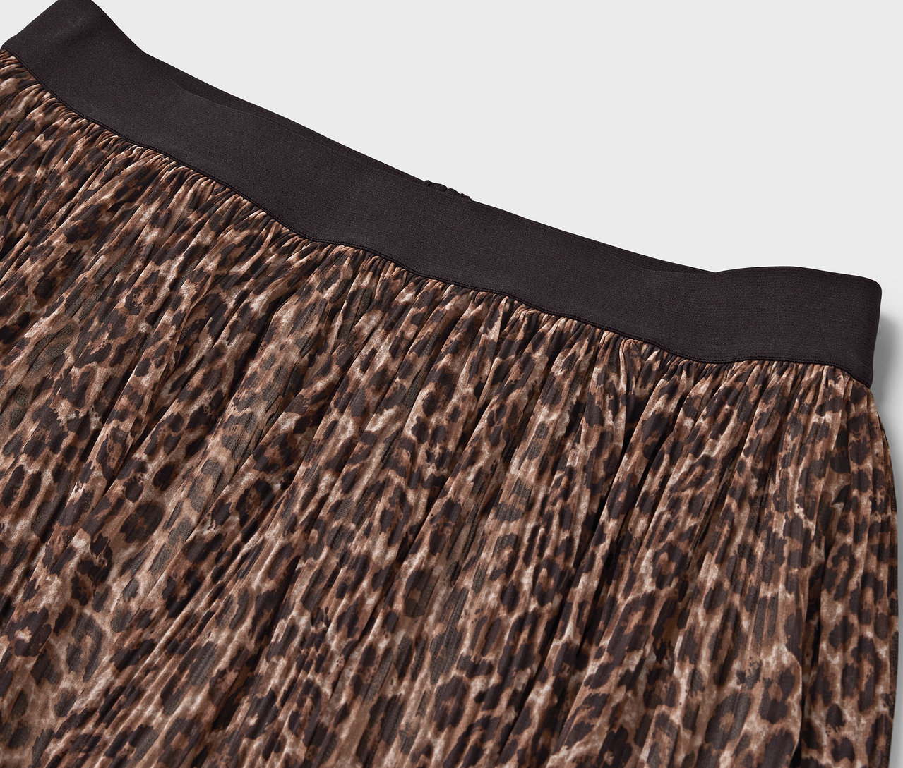 Detailaufnahme eines braunen Rocks mit Tiermuster und schwarzem Bund.