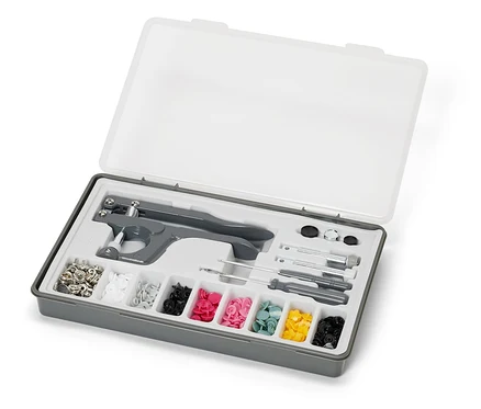 Offene graue Box mit transparentem Deckel, die ein Druckknopf-Set enthält.