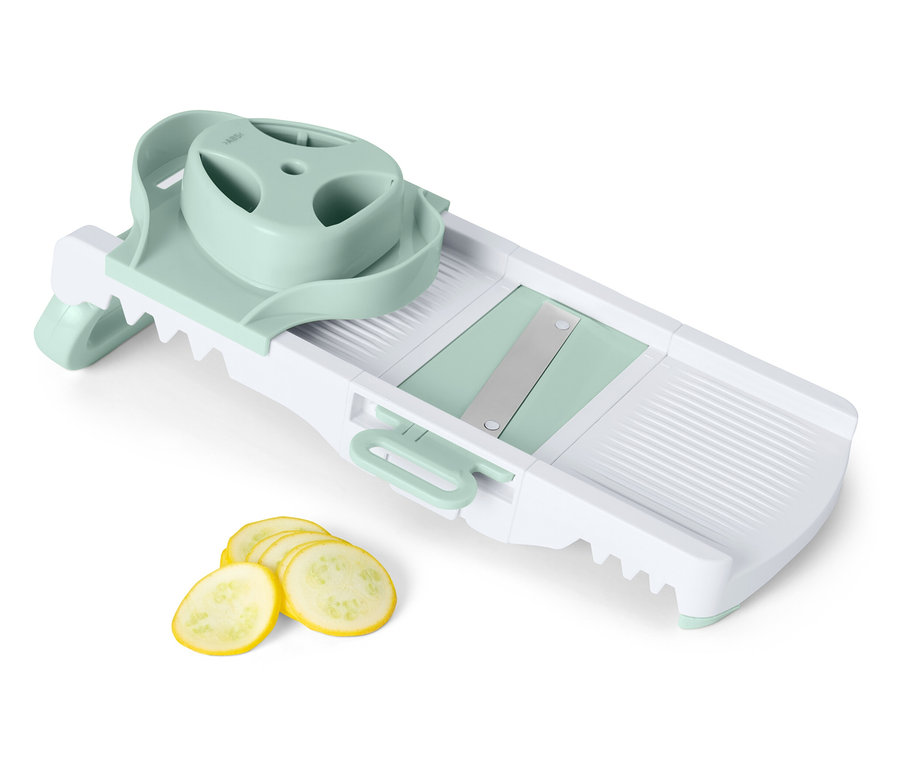Gemüsehobel mit Scheiben gelber Zucchini.