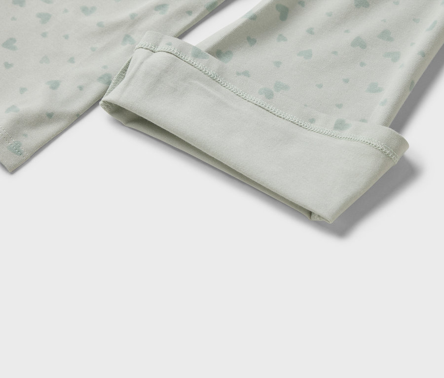 Detail einer hellgrünen Leggings mit hellblauem Herzmuster und umgeschlagenem Saum.