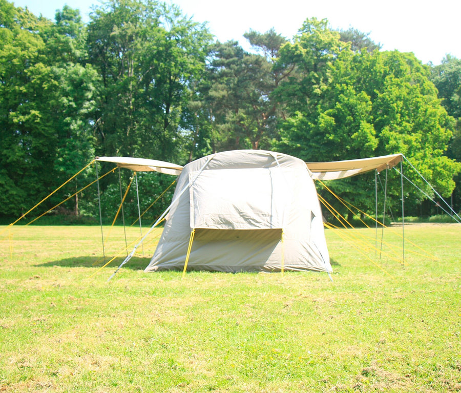 Ein Tambu 4-Personen-Familien-Luftzelt BISALA 4 steht auf einer grünen Wiese.