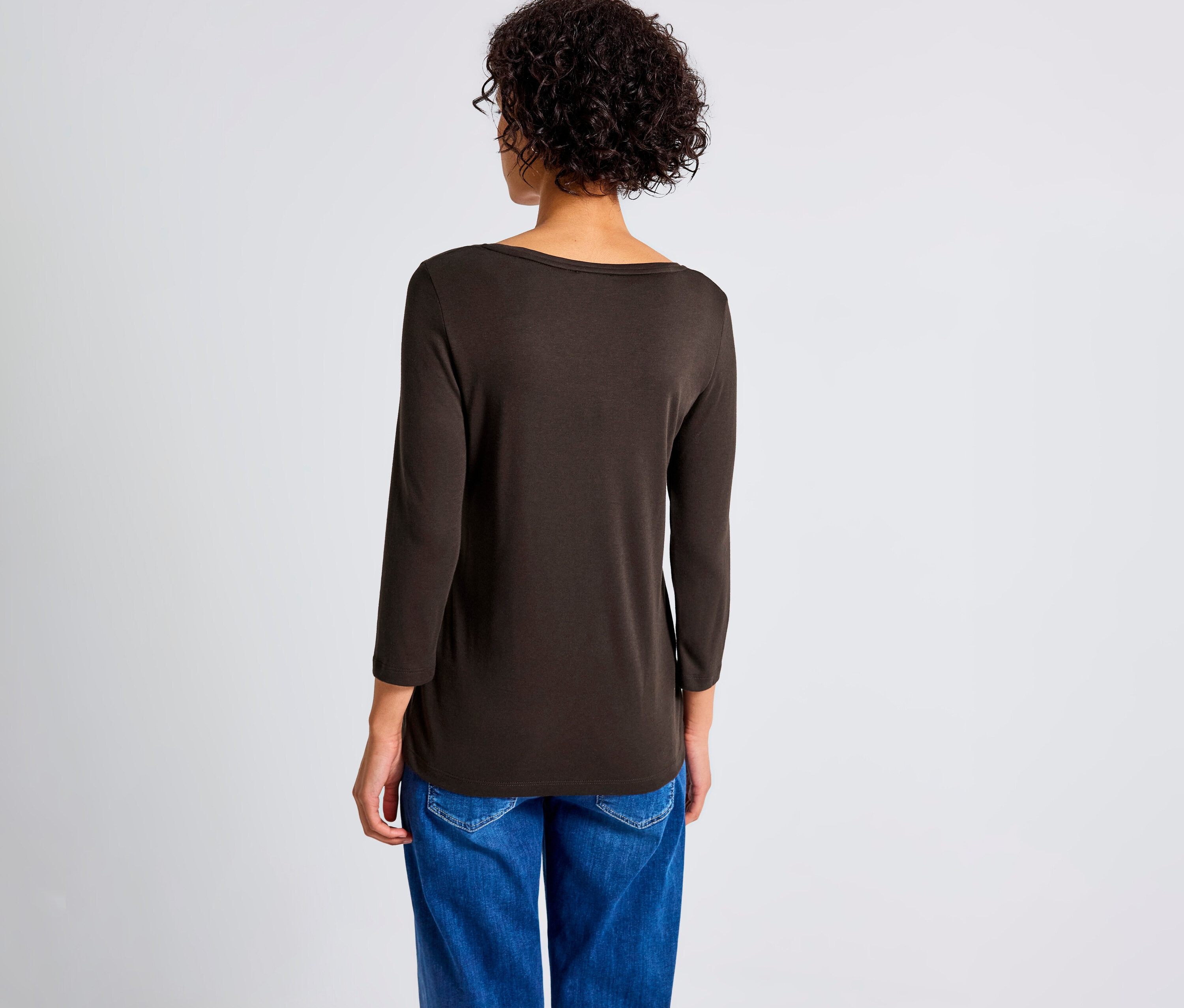Rückansicht einer Frau mit braunem Street One 3/4-Shirt mit Knopfdetail und blauen Jeans.