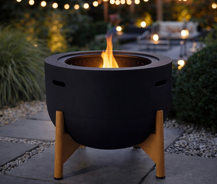 Die schwarze RedFire Feuerschale »Jubilee« mit raucharmer Verbrennung steht auf einer Terrasse, in der Feuerschale brennt ein Feuer.