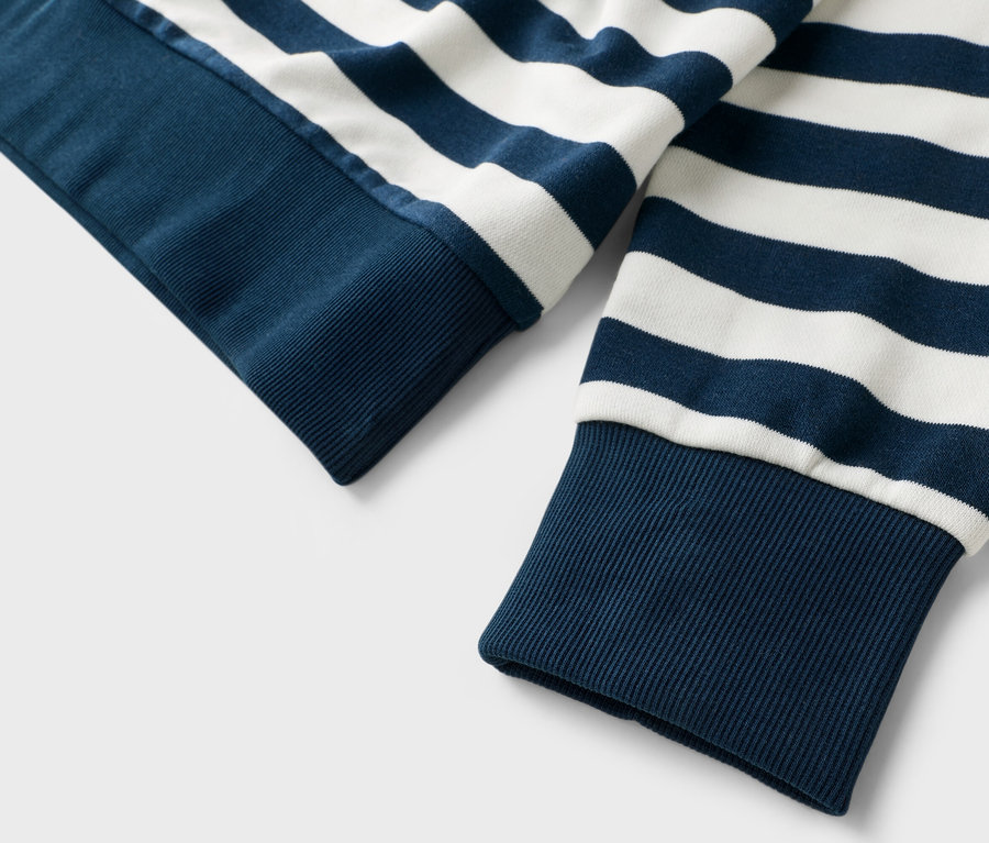 Nahaufnahme von Ärmeln eines blau-weiß gestreiften Pullovers.