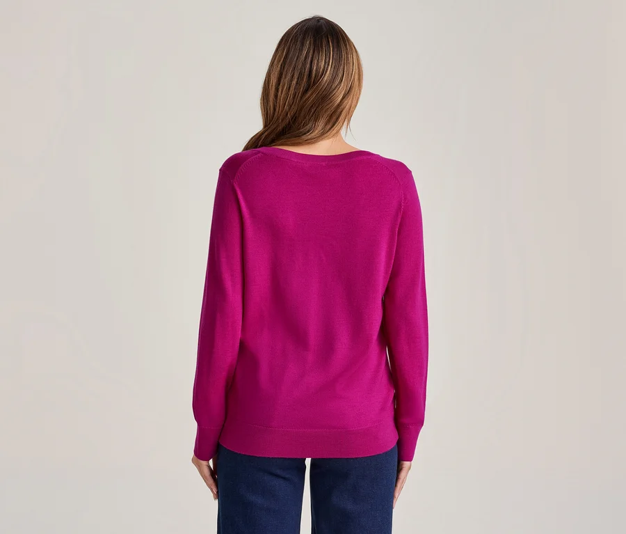 Frau von hinten, trägt ein magentafarbenes Langarmshirt und dunkelblaue Jeans.