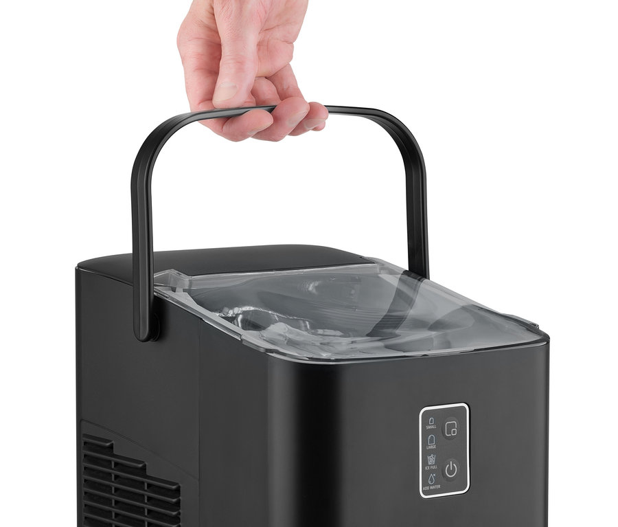 Hand hält den schwarzen CASO IceChef Compact Eiswürfelbereiter am oberen Griff, der seinen transparenten Deckel und das Bedienfeld zeigt.