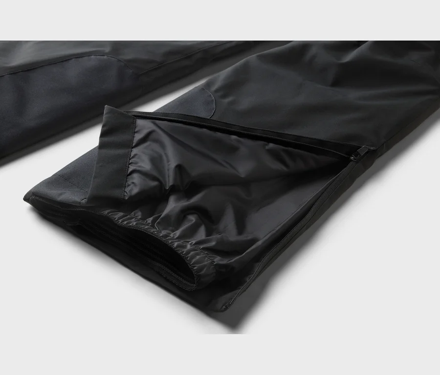 Schwarze Hose mit offenem Reißverschluss am Bein, der ein gerafftes Innenfutter und einen elastischen Bund zeigt.