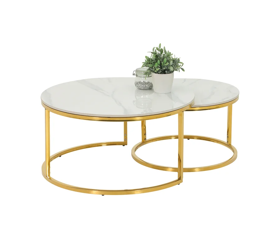 Zwei ineinander geschobene Hela Couchtische „Joel“ mit runden, weißen Marmorplatten und goldenen Metallgestellen. Auf dem größeren Tisch stehen eine Pflanze und ein Glas mit Steinen.