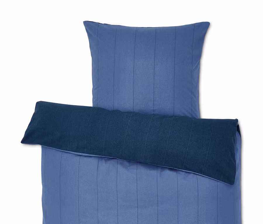 Blau gestreifte Bettwäsche mit Kissen.
