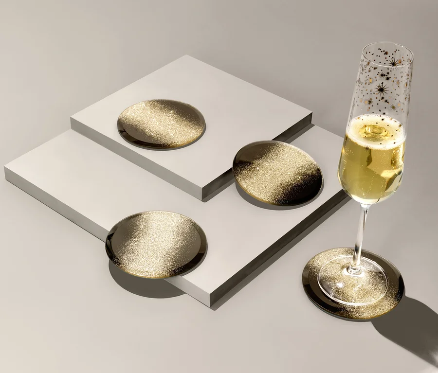 Ein Champagnerglas steht auf einem von 4 Glasuntersetzern.