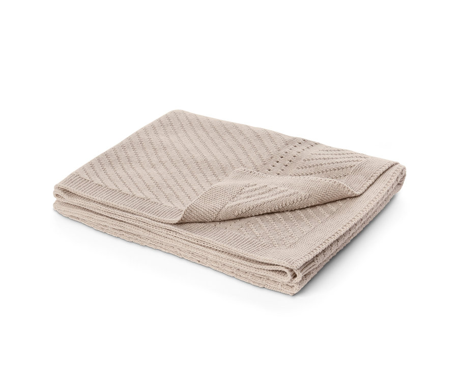 Gefaltete Kuscheldecke in Beige.