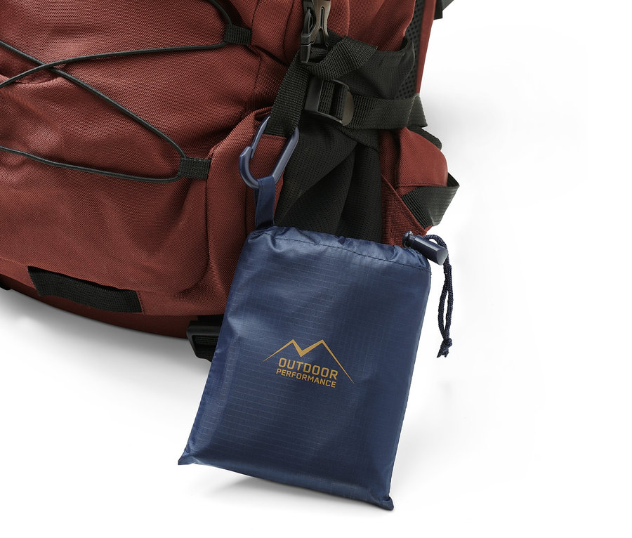 Eine Mini-Picknickdecke hängt an einem braunen Rucksack.