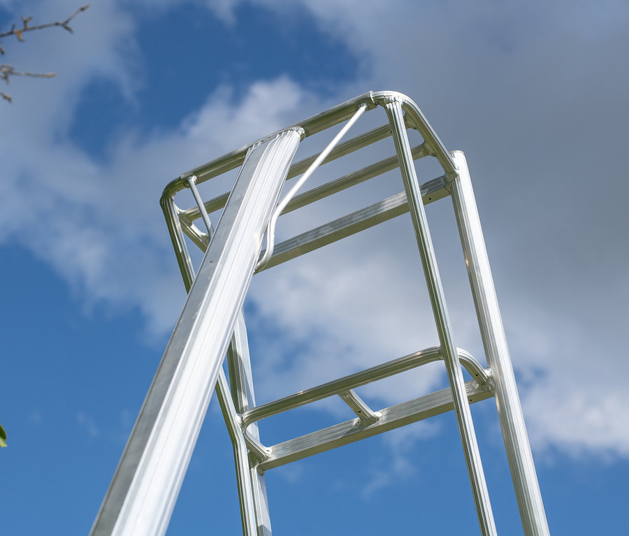 Ansicht von unten einer silbernen Niwaki-3-Holm-Gartenleiter vor blauem Himmel.