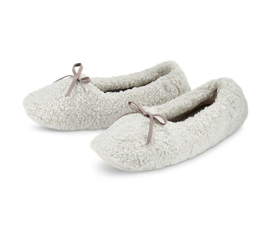 Zwei flauschige, weiße Hausschuhslipper mit Schleife.