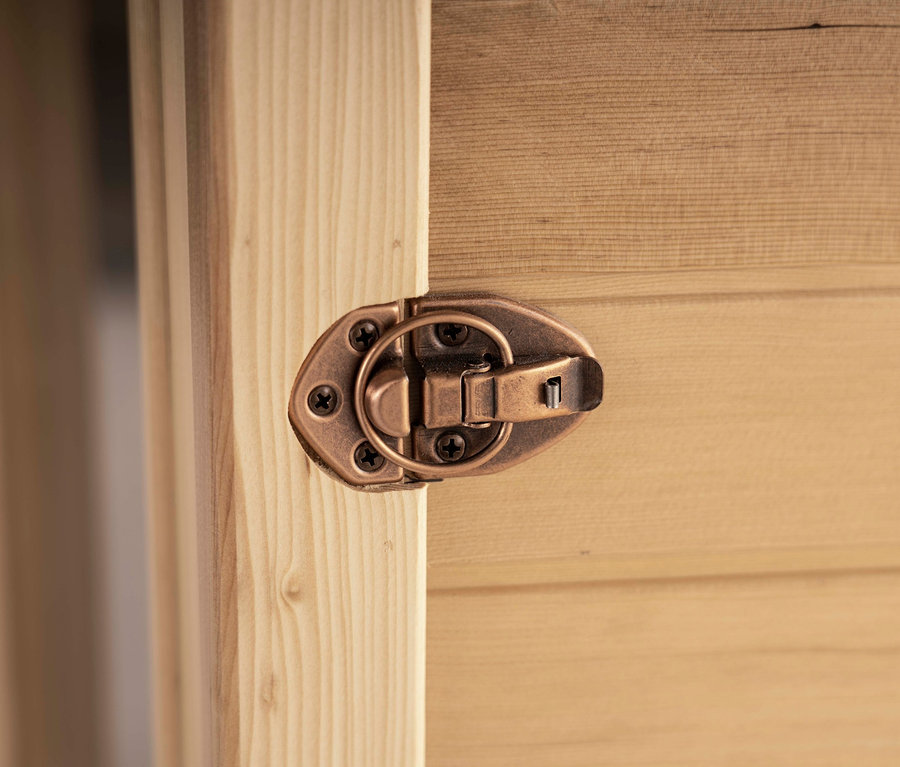 Nahaufnahme eines bronzefarbenen Verschlusses an einer Home Deluxe Infrarotkabine »SAHARA XXL« aus Holz.