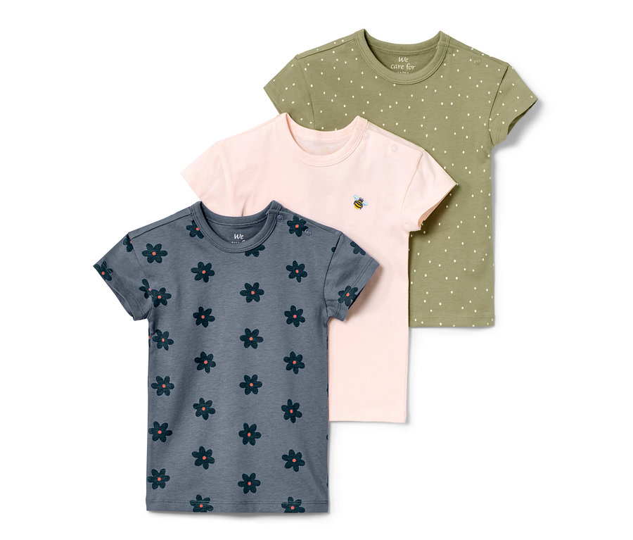 Drei Kinder-T-Shirts: blau mit Blumen, rosa mit Biene und grün mit Punkten.