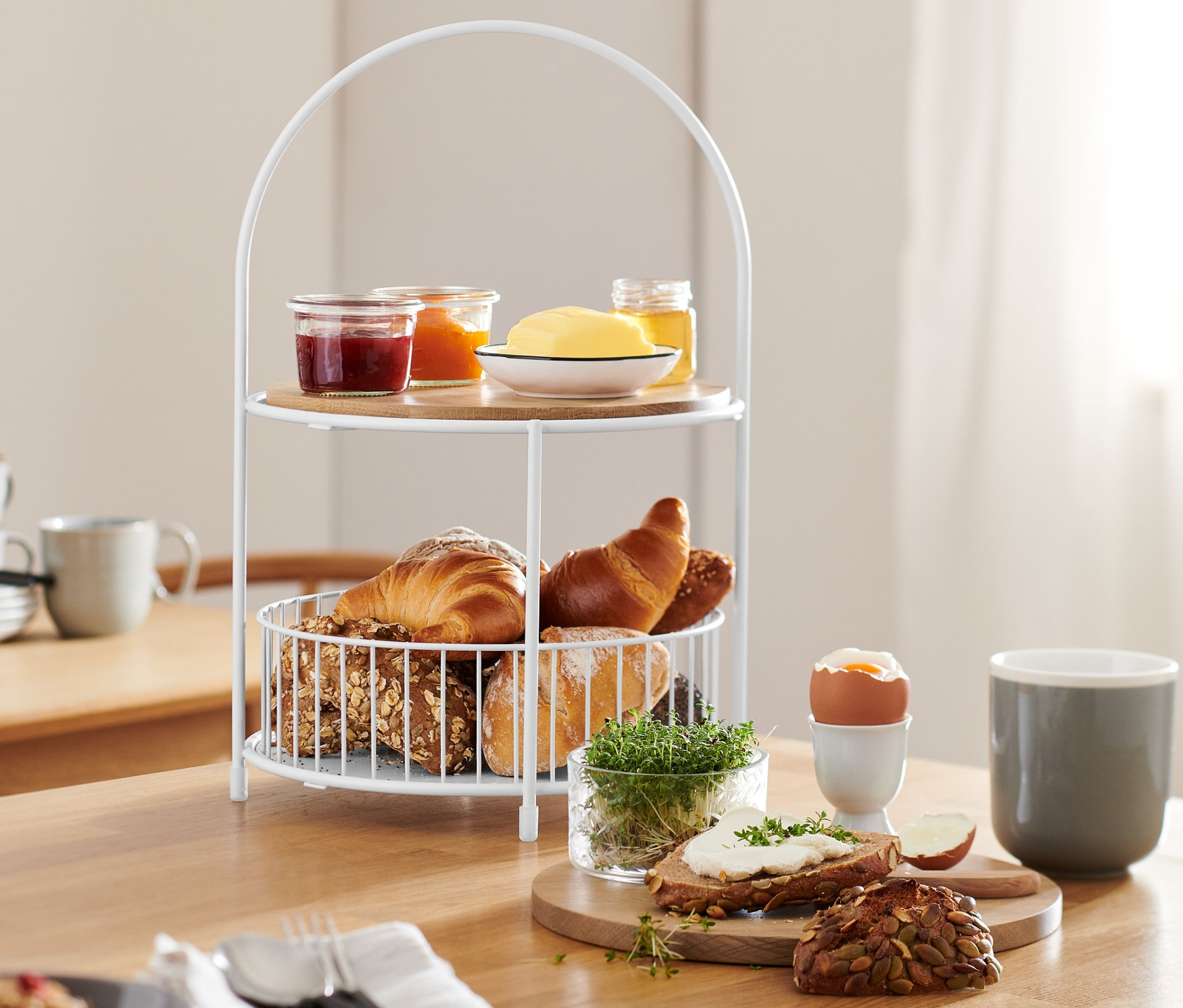 Etagere mit Brotkorb auf einem Tisch mit Speisen.