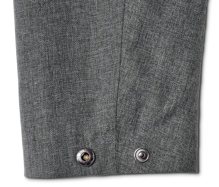 Detailaufnahme einer grauen Allwetterjacke mit zwei silberfarbenen Druckknöpfen.