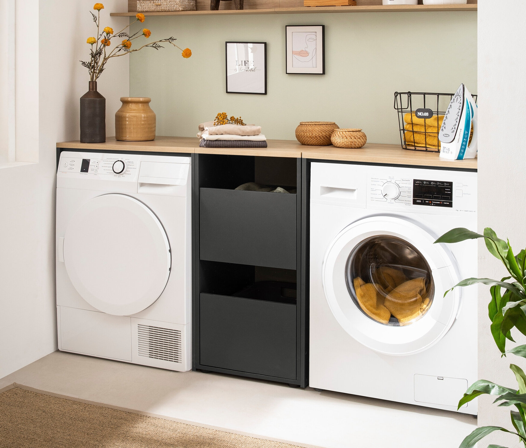 Waschmaschine und Trockner stehen nebeneinander, dazwischen der anthrazitfarbene Unterschrank »Solea« und darüber ein Regal.