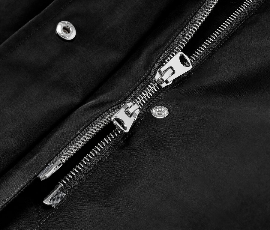 Detailaufnahme einer schwarzen Parka mit Kapuze und silbernem Reißverschluss.