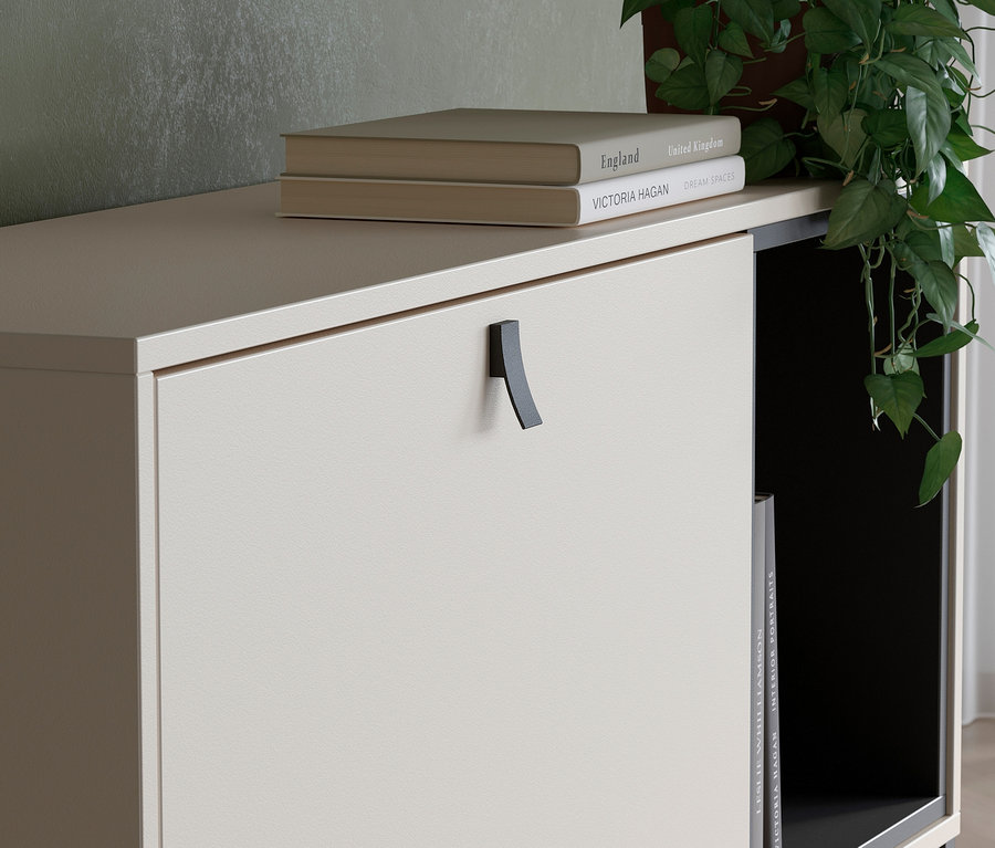 Detailansicht eines kaschmirfarbenen Sekretärs mit Büchern darauf und einer Pflanze an der Seite.