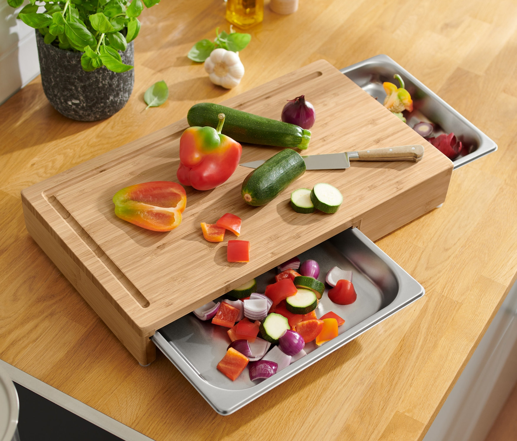 Gemüse geschnitten auf einem Schneidebrett mit Edelstahltabletts.