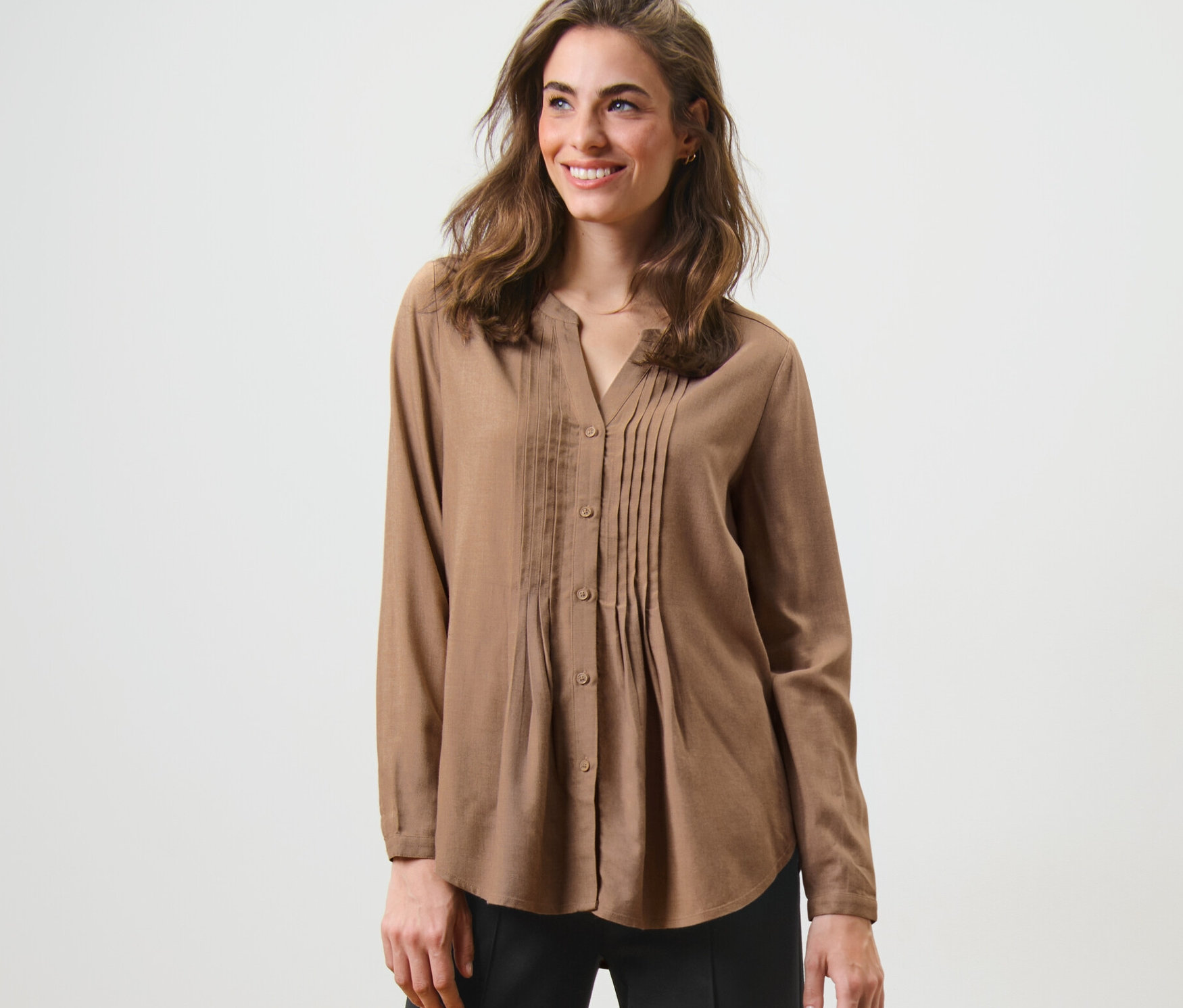 Frau posiert in Tunikabluse.