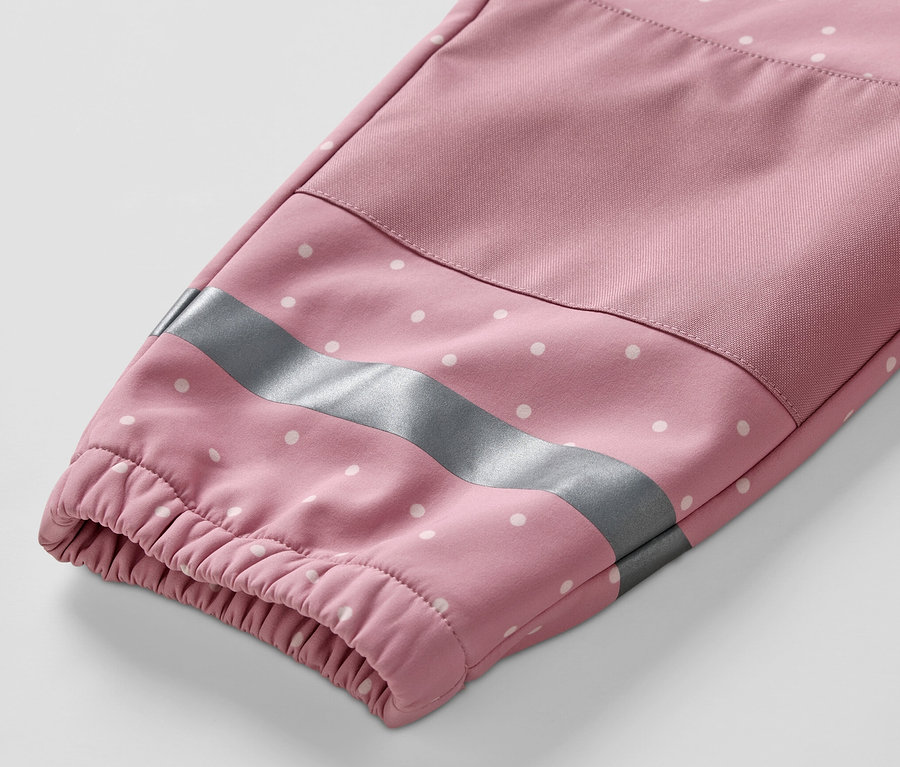 Detailansicht des Ärmels eines Kinder-Softshell-Einteilers mit weißen Punkten und einem reflektierenden Streifen.