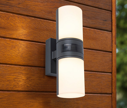 LED-Outdoor-Wandleuchte mit Bewegungsmelder ist an einer Holzwand befestigt.
