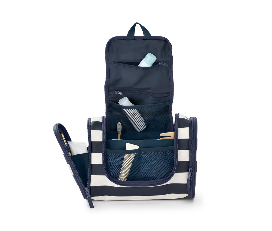 Geöffnete Kulturtasche mit blauen und weißen Streifen, gefüllt mit Toilettenartikeln.
