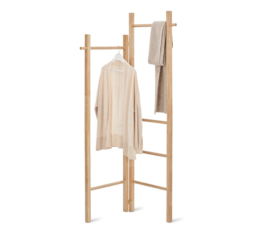 Ein Pullover hängt auf einem Bügel an einer Kleiderleiter, daneben hängt ein Schal.