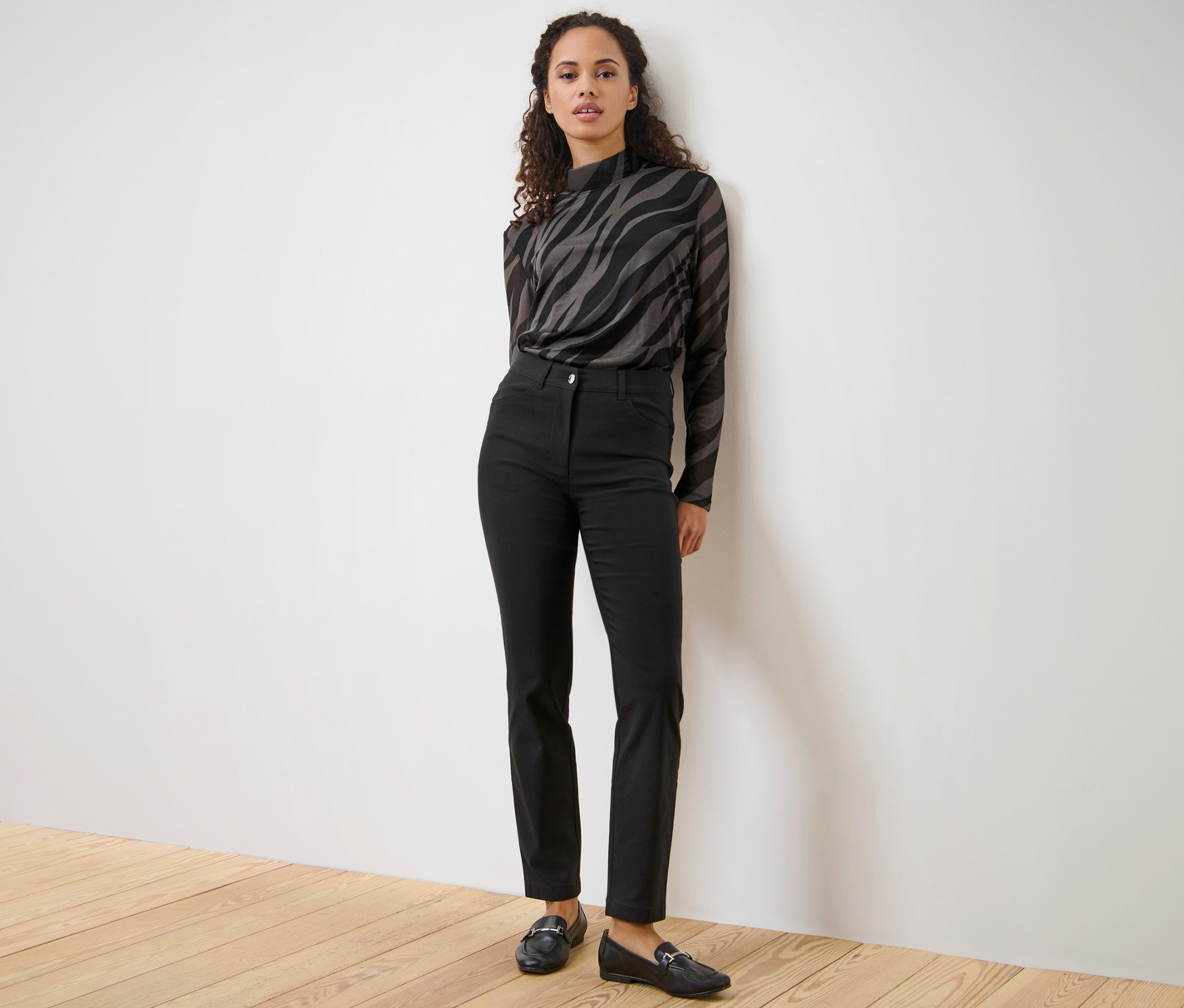 Frau posiert in schwarzer Bengalin-Hose.