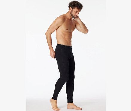 Mann posiert in langer, schwarzer SCHIESSER Unterhose mit Bio-Baumwolle.