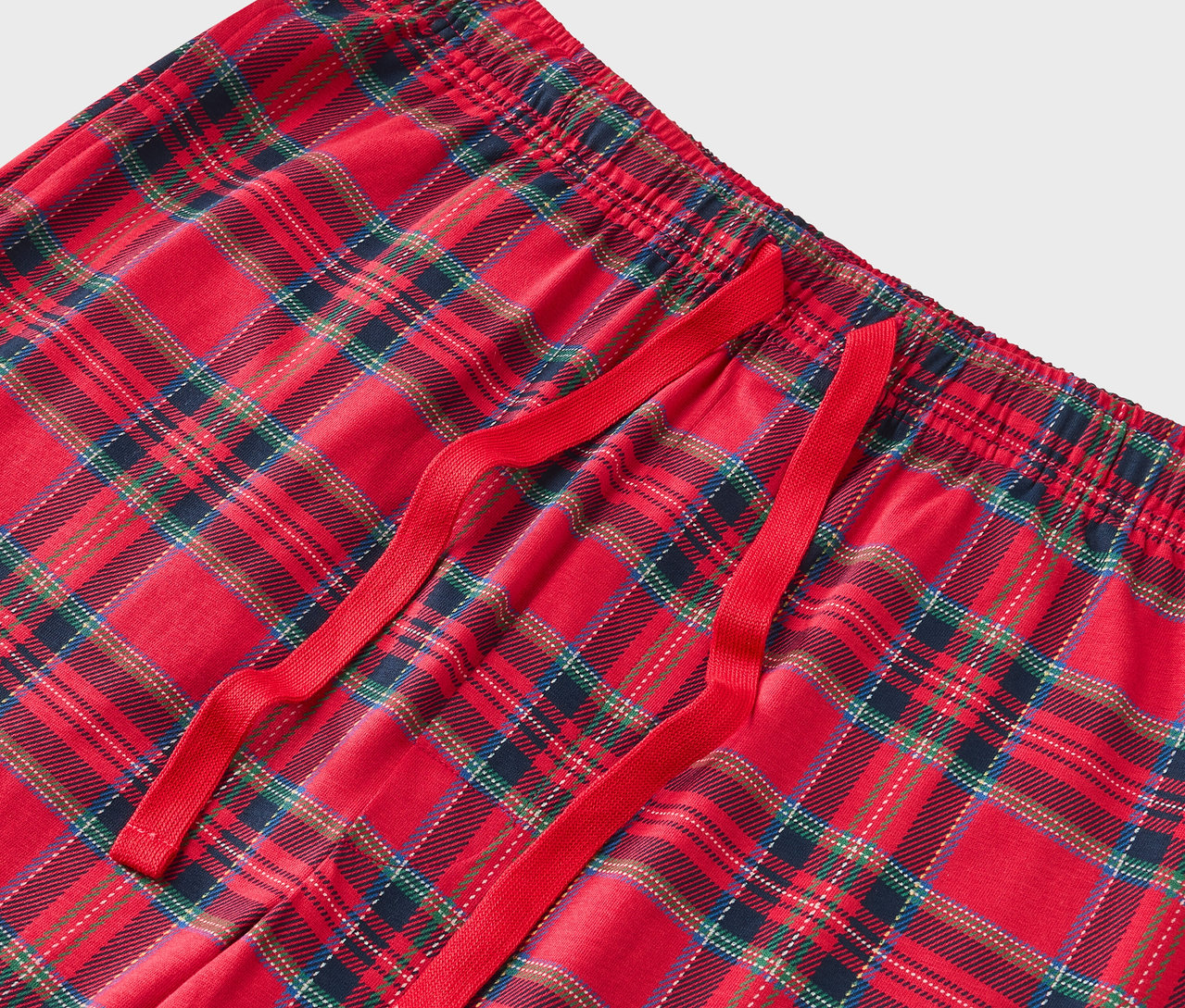 Detail einer rot karierten Pyjamahose mit rotem Kordelzug.