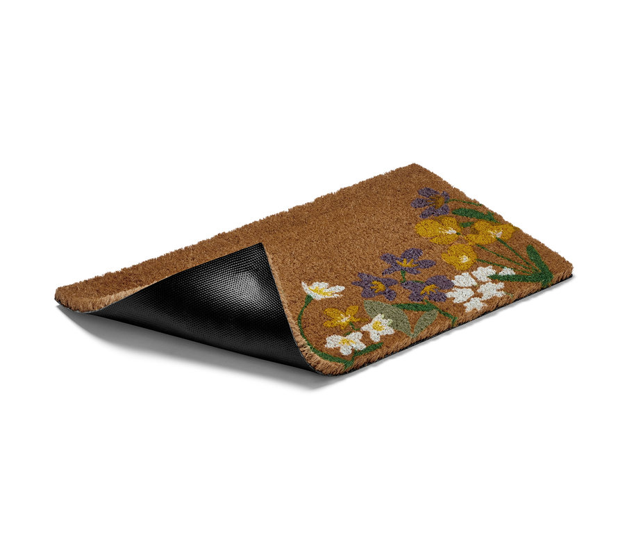 Eine braune Kokos-Fußmatte mit Blumenmuster.