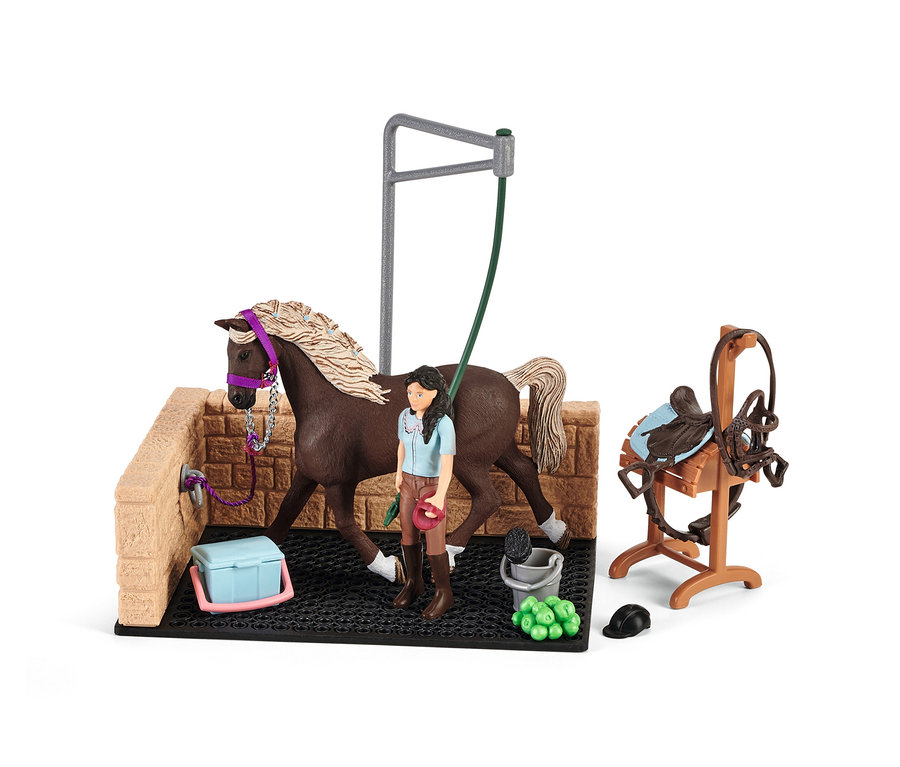 Ein braunes Pferd mit blonder Mähne steht auf dem Schleich »Horse Club« Waschplatz mit einer Mädchenfigur und Zubehör.