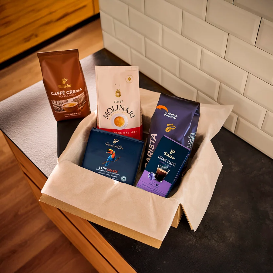 Eine Auswahl an Kaffeepackungen verschiedener Marken in einer Papierbox.